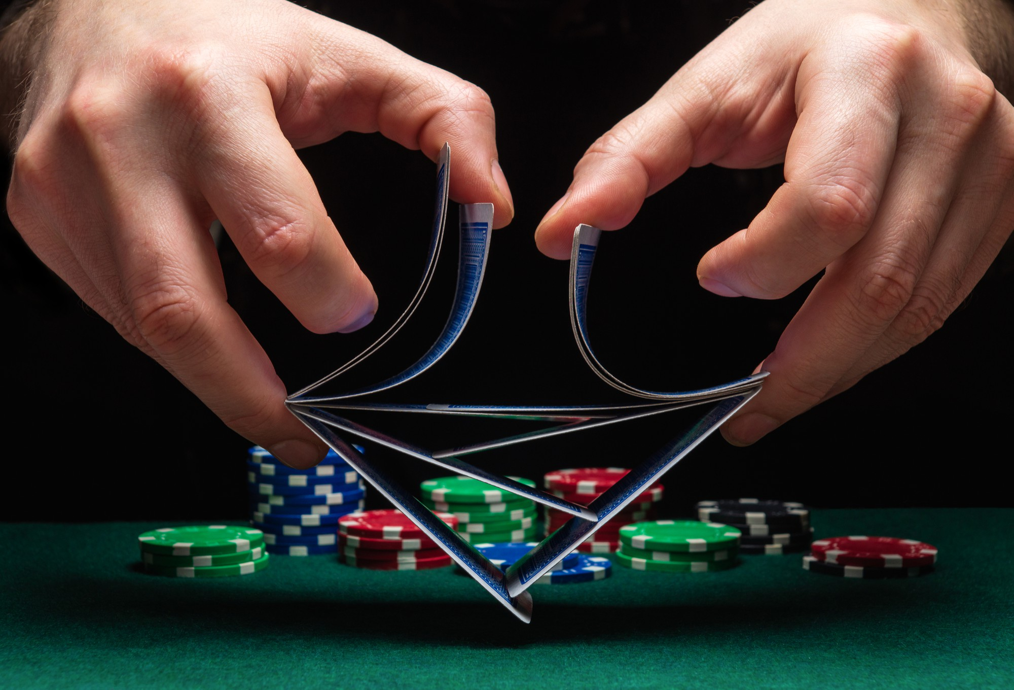 close-up-hands-person-dealer-croupier-shuffling-poker-cards-casino-background-table-chips